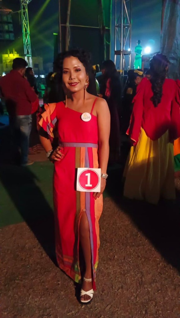 Pageant contestant in a red Womania gown with brand badge