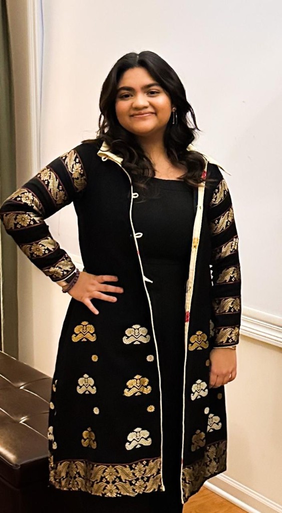 Client in black gold-embroidered Womania jacket